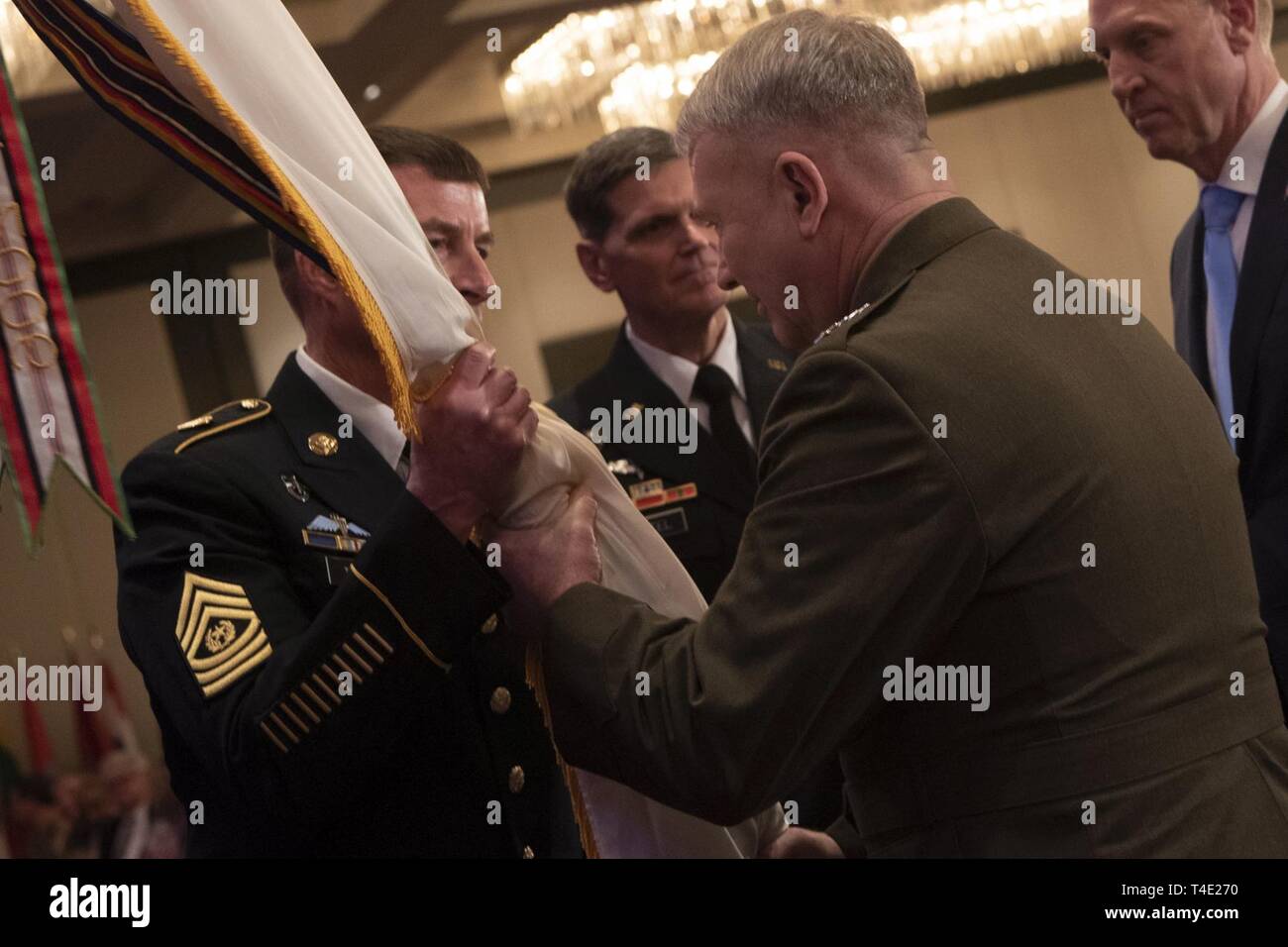 The new commander of U.S. Central Command, U.S. Marine Corps Gen. Kenneth F. McKenzie Jr., passes the colors to U.S. Army Command Sgt. Maj. William F. Thetford, during the Centcom change of command ceremony, Tampa, Florida, March 28, 2019. Stock Photo