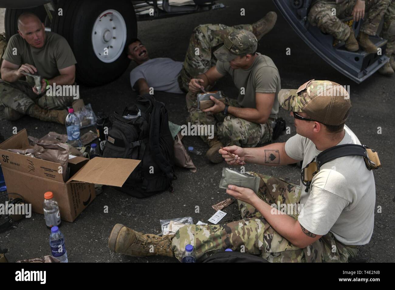 U.S. service members assigned to Combined Joint Task Force-Horn of Africa (CJTF-HOA) break for meals, ready to eat (MREs) outside a C-130J Hercules at Maputo International Airport, Mozambique, March 28, 2019, for the U.S. Department of Defense’s relief effort in the Republic of Mozambique and surrounding areas following Cyclone Idai. Teams from CJTF-HOA, which is leading DoD support to relief efforts in Mozambique, began immediate preparation to respond following a call for assistance from the U.S. Agency for International Development’s Disaster Assistance Response Team. Stock Photo