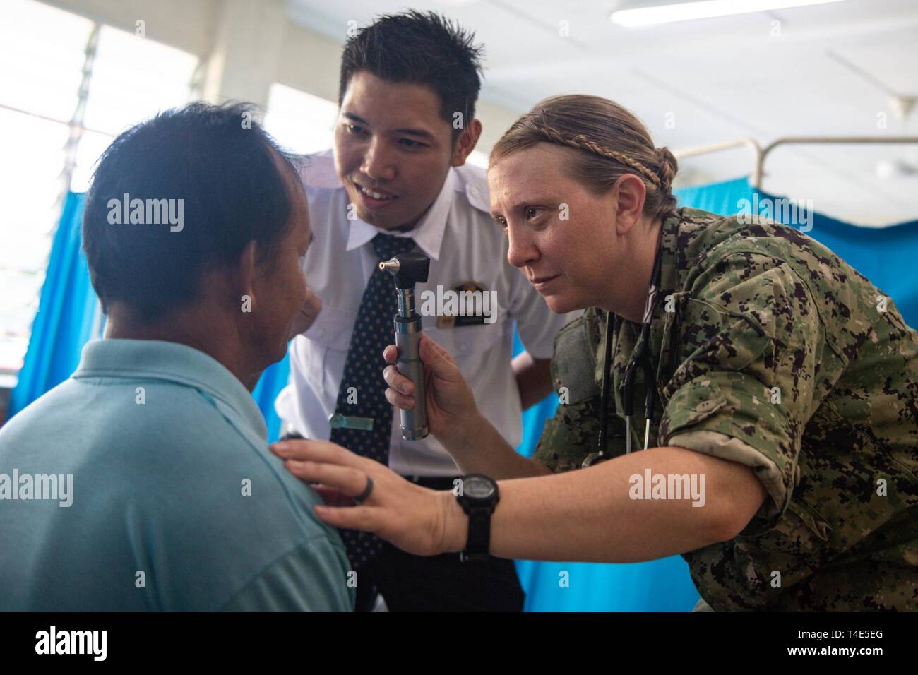 Kuching Malaysia March 31 2019 U S Navy Lt Sharon Hoff And Malaysian Paramedic Daniel Kandy Examine The Pupils Of A Patient During A Community Health Engagement At Sk Tanah Puteh As
