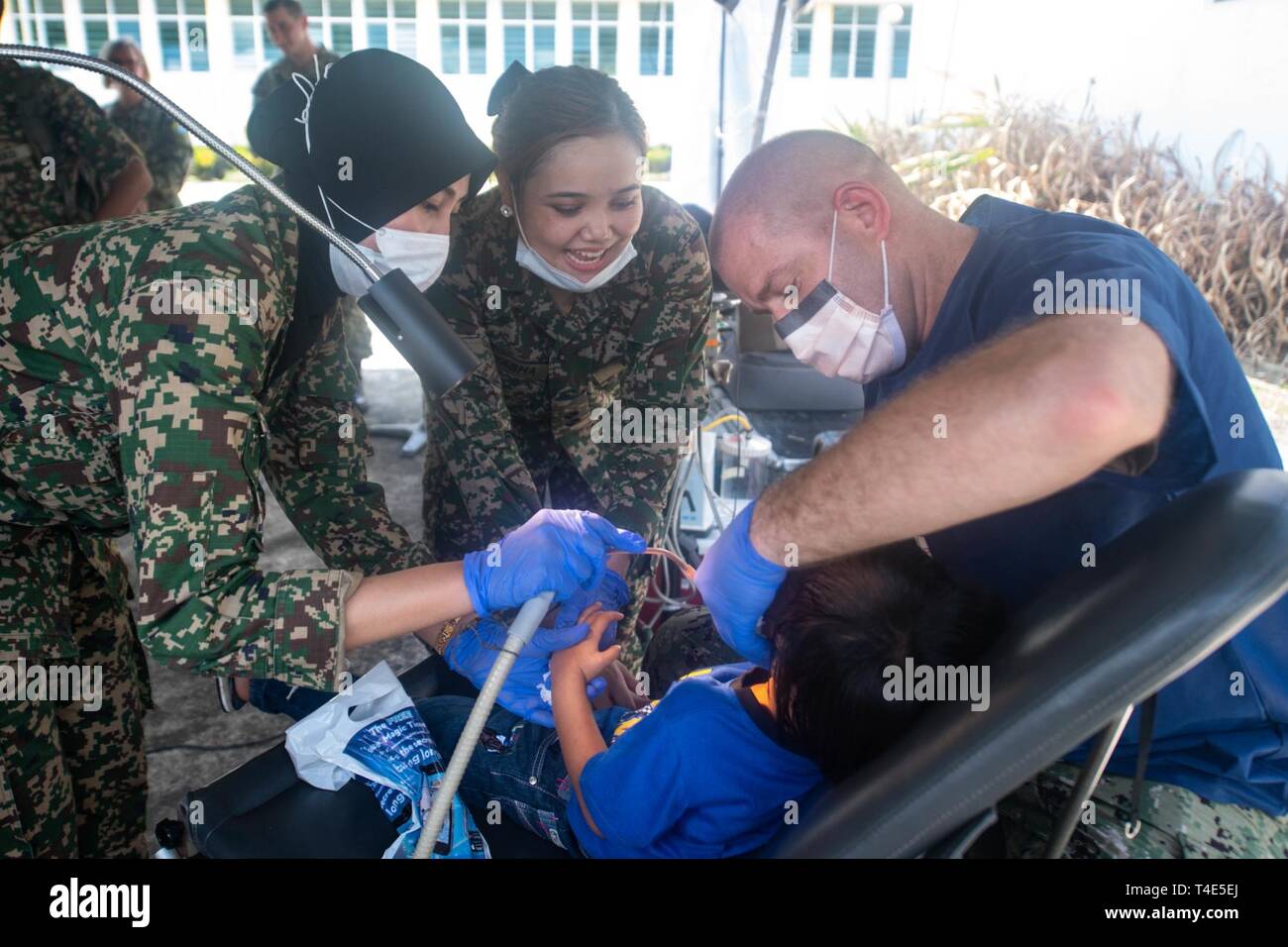 Kuching Malaysia March 31 2019 Malaysian Army Sgt Marlianna Marzuki Left Lt Natasha Eleena And U S Navy Lt Cmdr Eric Bischoff Perform A Dental Procedure On A Patient During A Community