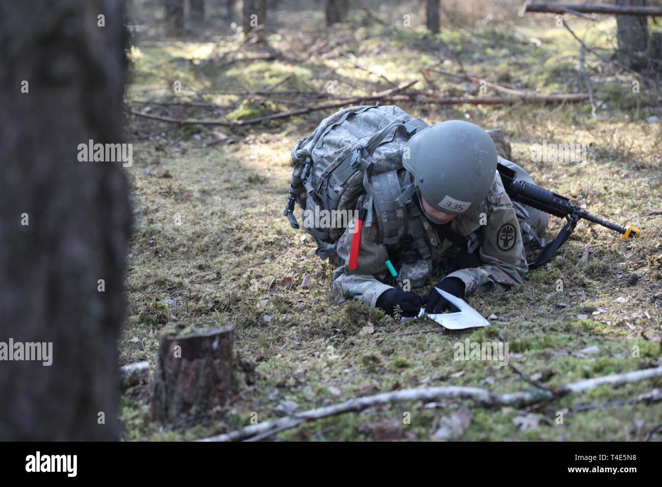 Spc. Vanessa Iturri, Regional Health Command Europe, fills out a situation report on a simulated unexploded ordnance at Grafenwoehr Training Area, Germany, March 31, 2019. Iturri is the last Soldier in her Platoon trying to earn the Expert Field Medical Badge. Stock Photo