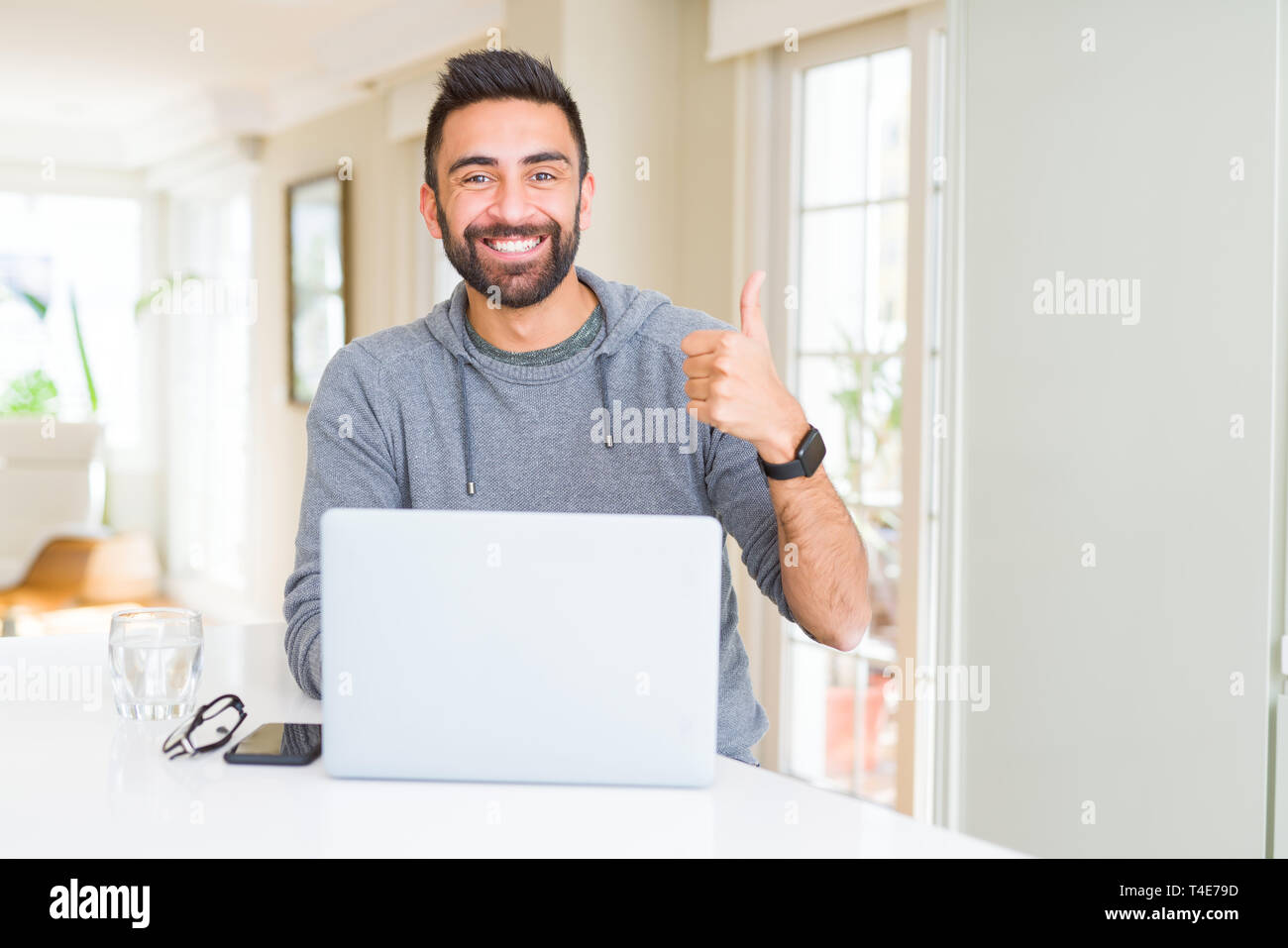 Handsome hispanic man working using computer laptop happy with big ...
