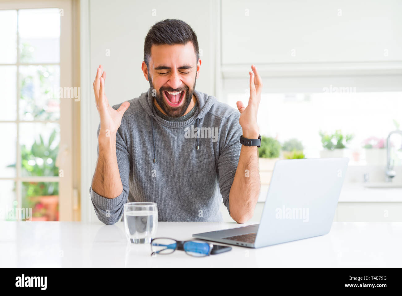 Hispanic Man Using Computer Handsome hispanic man working using computer laptop celebrating mad and ...