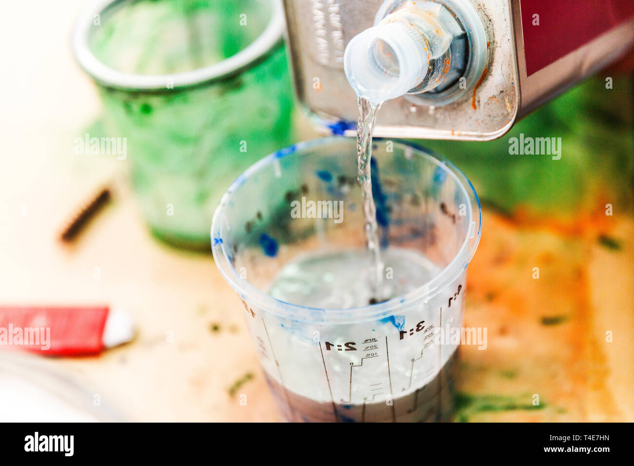 Methylated spirits pouring into paint measuring cup Stock Photo Alamy