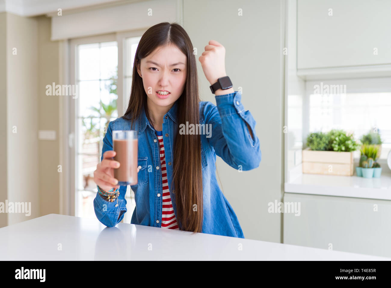 Beautiful Asian woman drinking a fresh glass of chocolate milkshake ...
