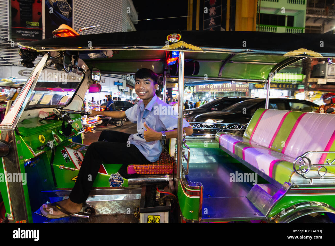BANGKOK, THAILAND - MARCH 2019: tuk-tuk taxi driver at China town night market looking into the camera Stock Photo