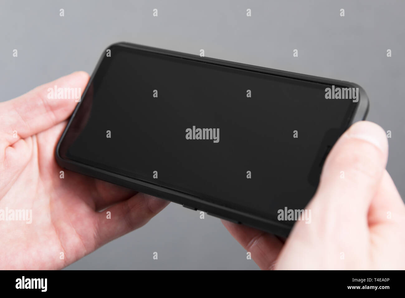 Mans hand holding black screen mobile phone Stock Photo - Alamy