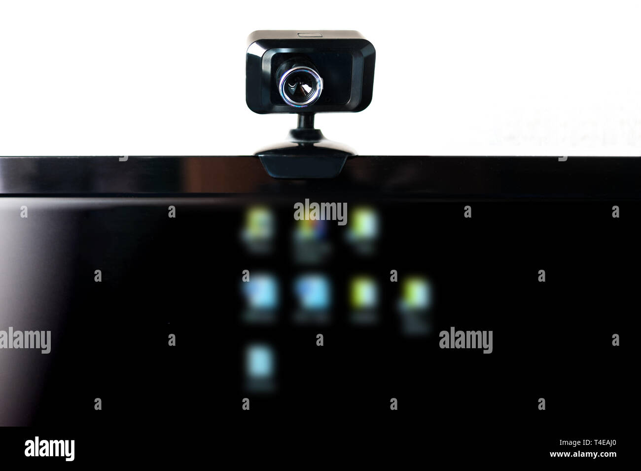 USB Webcam, Web Camera, Mounted on Computer Monitor with Blurred Icons on Black Screen. Data Protection, Cyber Security, Online Privacy. Social Media  Stock Photo