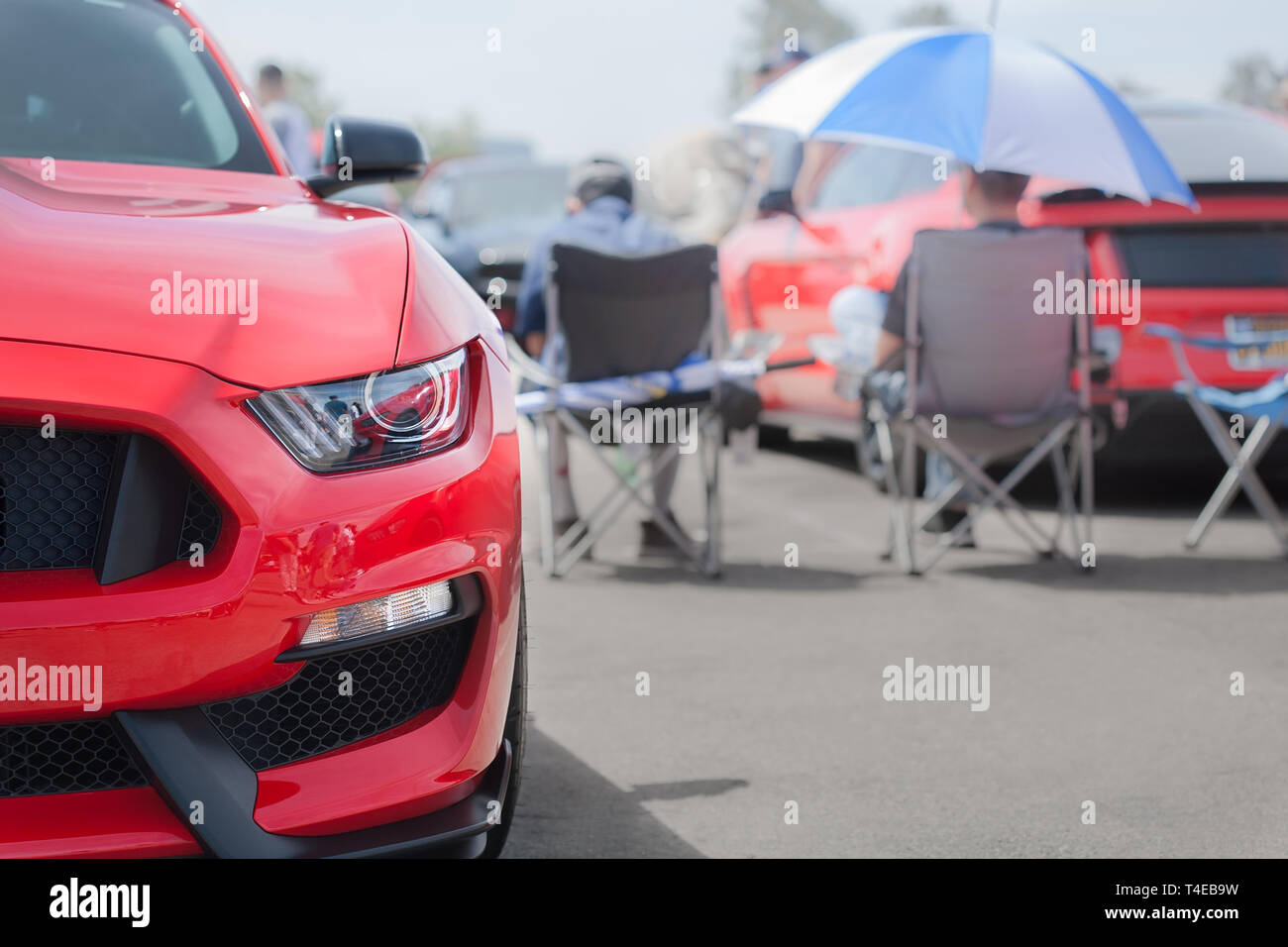 A mustang on display at the 2019 fabulous fords forever auto show with car owners sitting in the background. Stock Photo