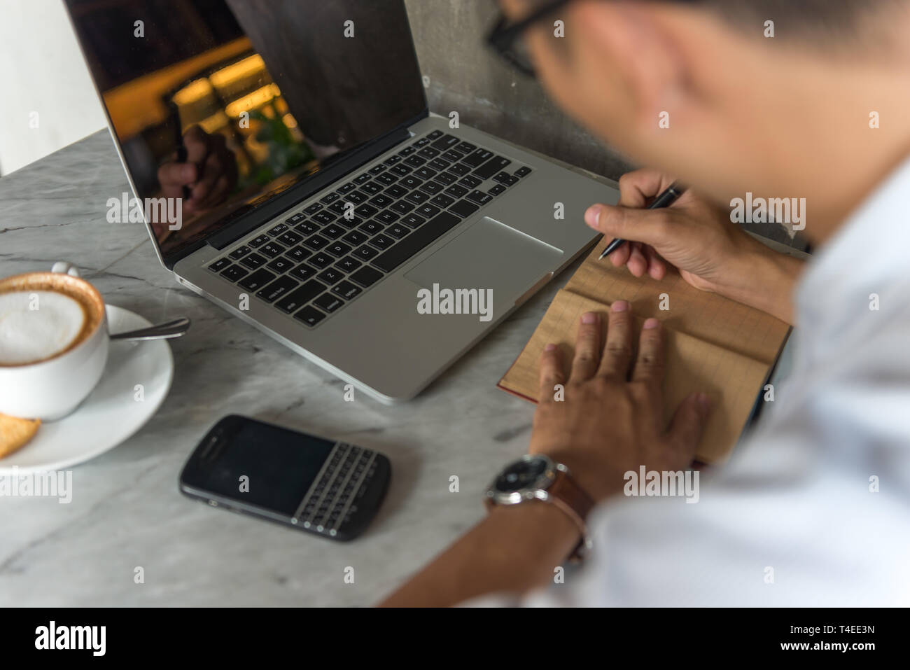 Side view of young man writing notes Stock Photo