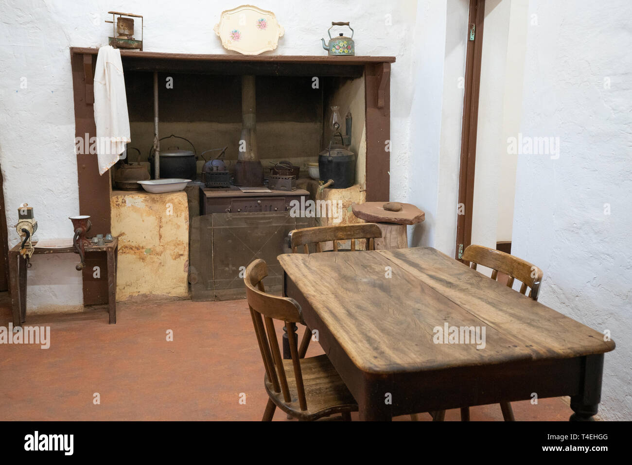 Basic old vintage kitchen with rustic wood table woodburner and white