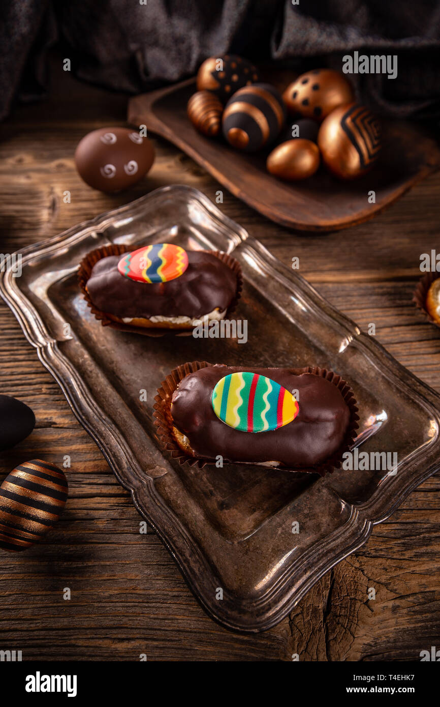 Pastry cream puff with chocolate ganache covering and Easter decoration Stock Photo