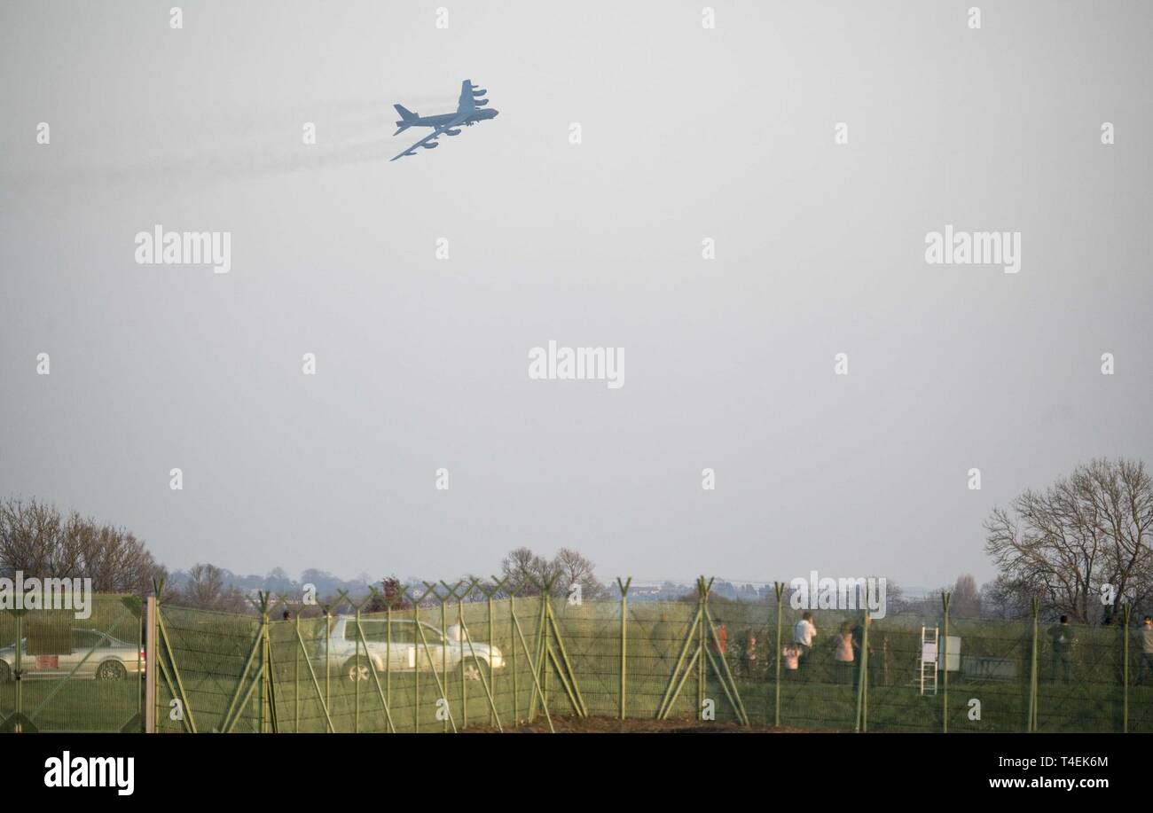 Aviation enthusiasts and community members watch as a B-52 Stratofortress deployed from Barksdale Air Force Base, La., returns to RAF Fairford, England, March 28, 2019. Lining the exterior fences since the five B-52s’ arrival to Fairford, the mostly English crowd photographed and cheered as the aircraft returned from their mission over the Norwegian Sea. Stock Photo