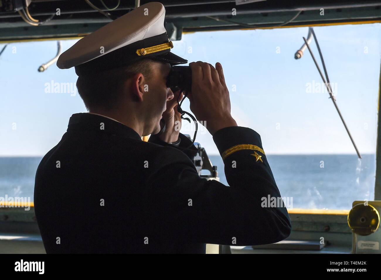 NORFOLK, Va. (April 1, 2019) Ensign John Broughton, from Shreveport, La., assigned to the Arleigh Burke-class guided-missile destroyer USS Nitze (DDG 94), stands watch on the bridge as the ship pulls out of port. Nitze departs Naval Station Norfolk as part of Abraham Lincoln Carrier Strike Group (ABECSG) deployment in support of maritime security cooperation efforts in the U.S. 5th, 6th and 7th Fleet areas of responsibility. With Abraham Lincoln as the flagship, deploying strike group assets include staffs, ships and aircraft of Carrier Strike Group 12 (CSG 12), Destroyer Squadron 2 (DESRON 2) Stock Photo