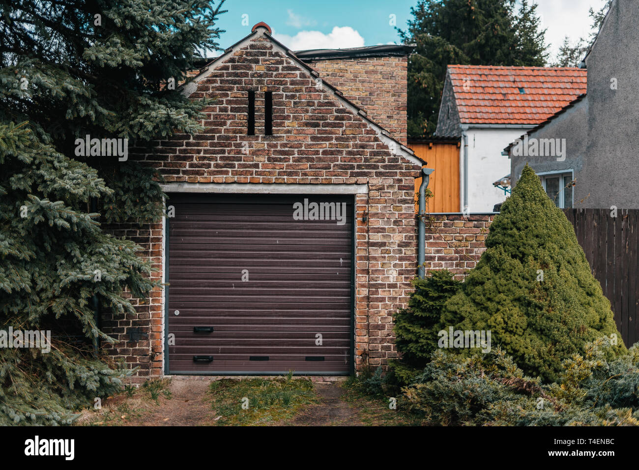 Traditional european garage with red brick and brown gate Stock Photo