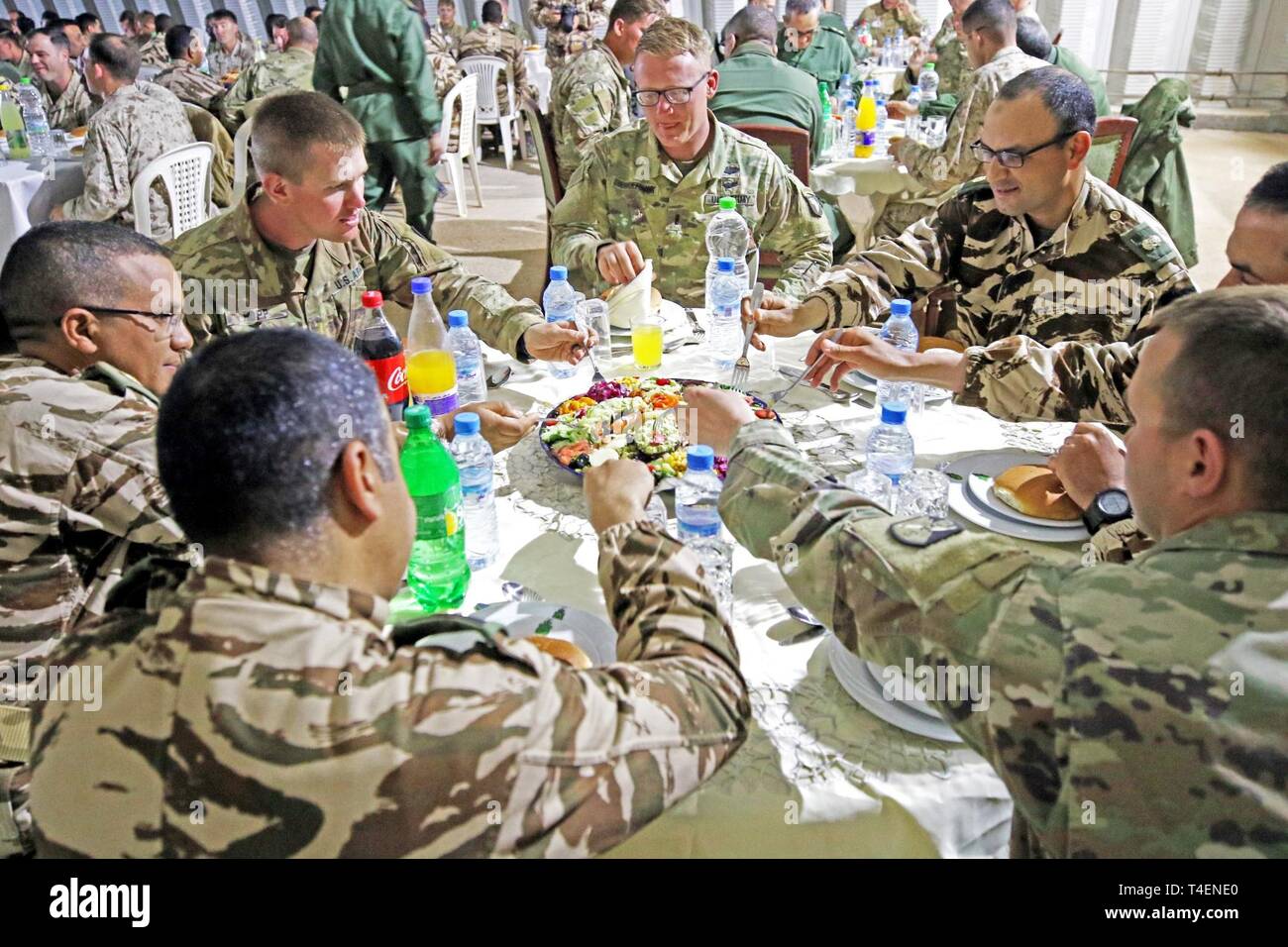 Members of the Royal Moroccan Armed Forces and U.S. military service members participating in the field training exercise in Tan Tan, Morocco, enjoy dinner, conversation and camaraderie at a Moroccan-style dinner hosted by the Moroccan FAR during exercise African Lion 2019, March 31, 2019, . The dinner provided an opportunity for service members from both countries to take a break from the field training exercise to share mutual experiences and reinforce the strong bond between the nations’ militaries. Stock Photo
