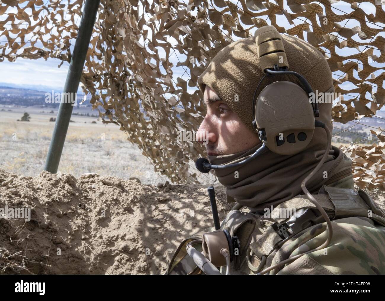 Airman 1st Class Timothy Jansen, 823d Base Defense Squadron (BDS) fire team member, keeps watch from his defensive fighting position during the Mission Readiness Exercise (MRX) at Camp Guernsey, Wyo., March 25, 2019. Throughout the MRX the 823d BDS practiced adaptive basing in support of National Defense Strategy objectives. Stock Photo
