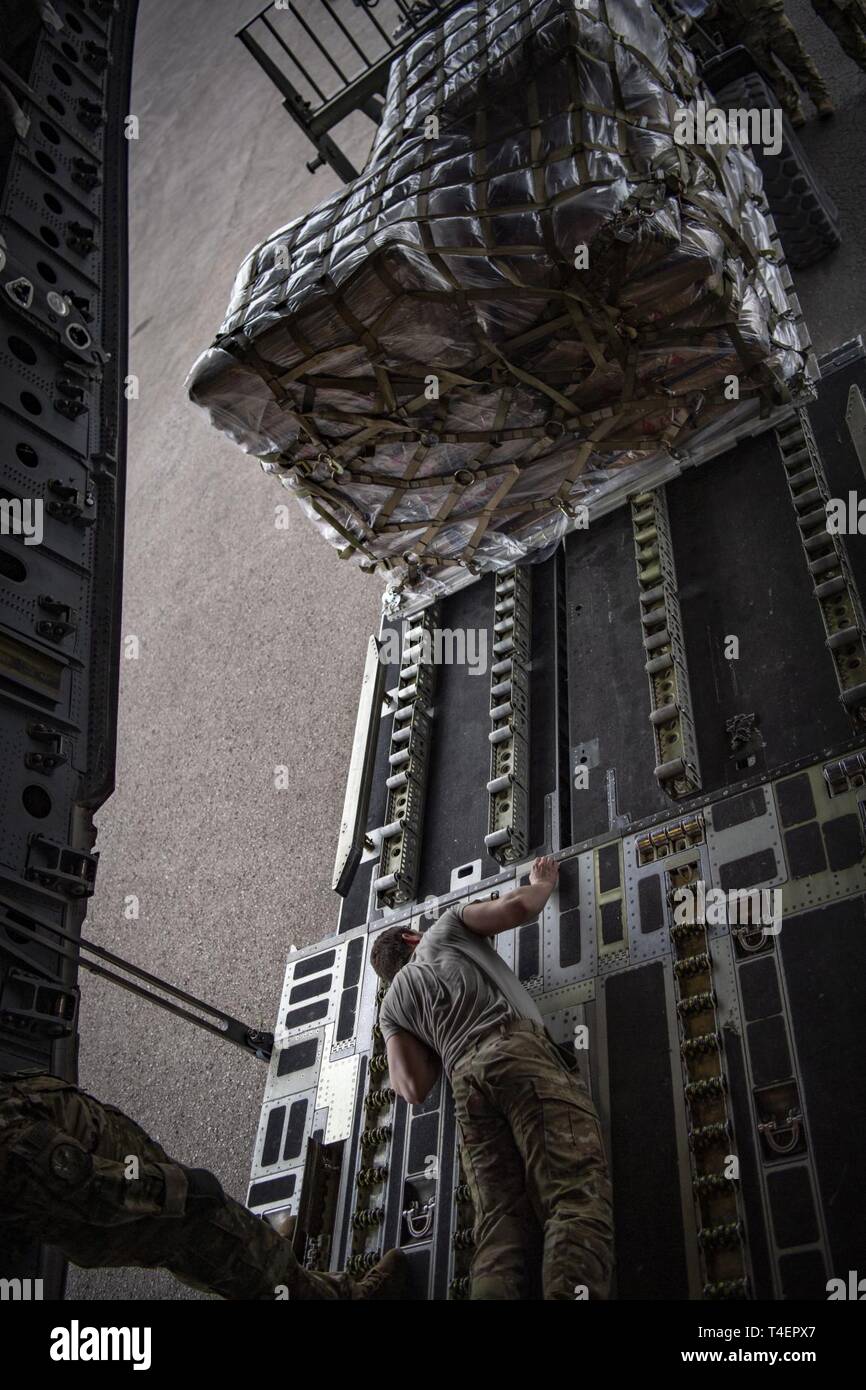 A U.S. Air Force loadmaster helps guide a forklift to the back of a C ...