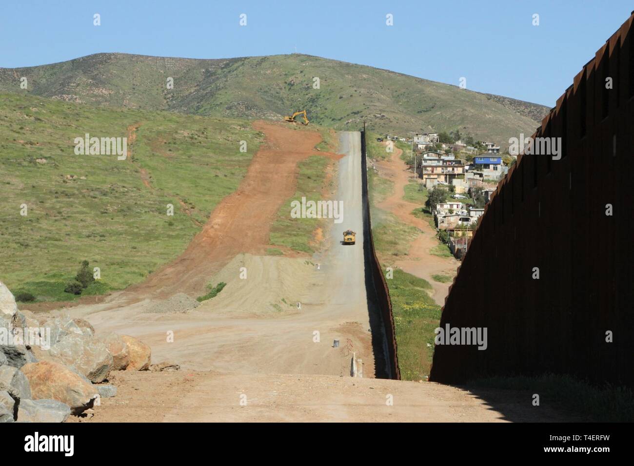 A view of the existing San Diego primary border wall (right) with "Tin Can Hill" in the background, and the cleared terrain for the San Diego secondary border wall (left) on March 28, 2019.  The Corps is supporting the Department of Homeland Security's request to build additional border wall near San Diego. Stock Photo