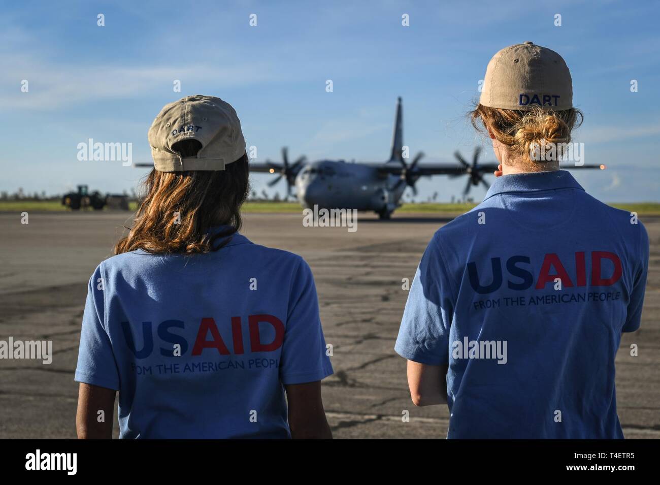 U.S. Agency for International Development (USAID) workers wait for a flight on a C-130J Hercules assigned to the 75th Expeditionary Airlift Squadron, Combined Joint Task Force-Horn of Africa, in Beira, Mozambique, April 3, 2019. The task force is helping meet requirements identified by USAID assessment teams and humanitarian organizations working in the region by providing logistics support and manpower to USAID at the request of the Government of the Republic of Mozambique. Stock Photo