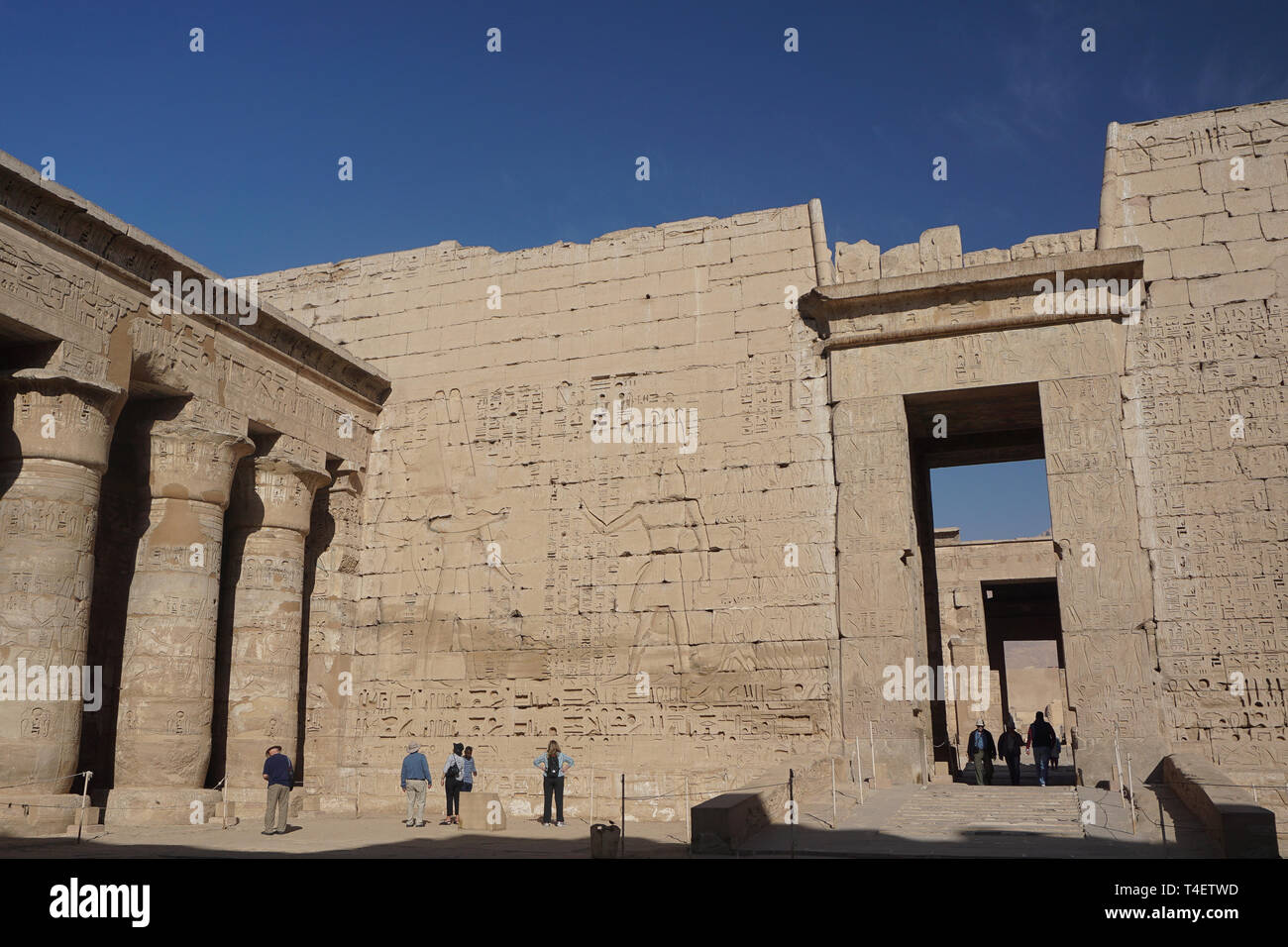 Luxor, Egypt: Tourists visit Medinet Habu, the mortuary temple of Ramesses III, an important New Kingdom structure on the West Bank of the Nile River. Stock Photo