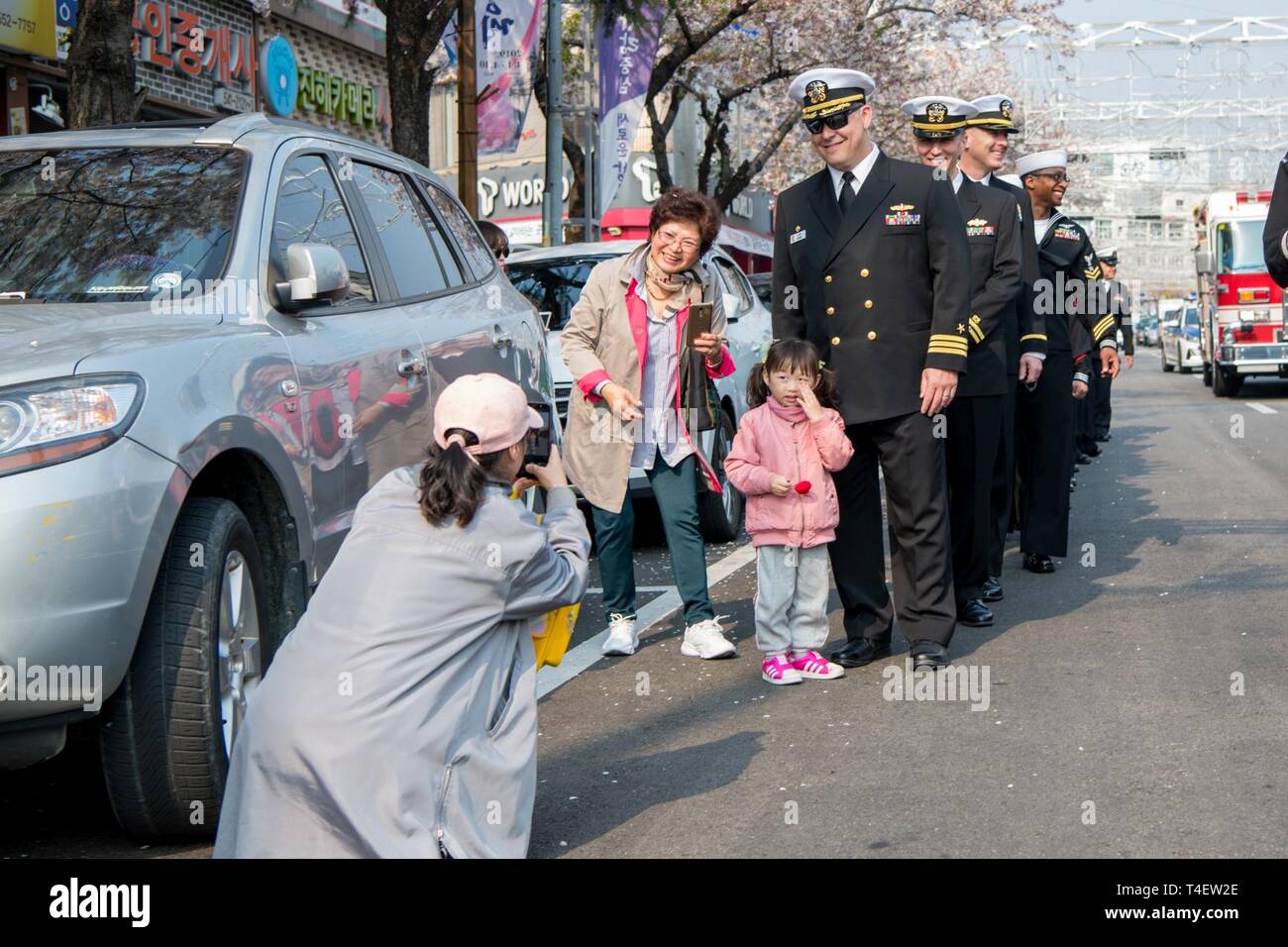 CHINHAE, Republic of Korea (April 05, 2019) Cmdr. Jeremy Ewing, commander, Fleet Activities Chinhae (CFAC) poses for a photo with a family during the 57th annual Jinhae Gunhangje military port festival parade. The festival honors Admiral Yi Sun-sin, a great naval hero of Korea, whose victories still inform the fighting spirit of the ROK Navy. Stock Photo