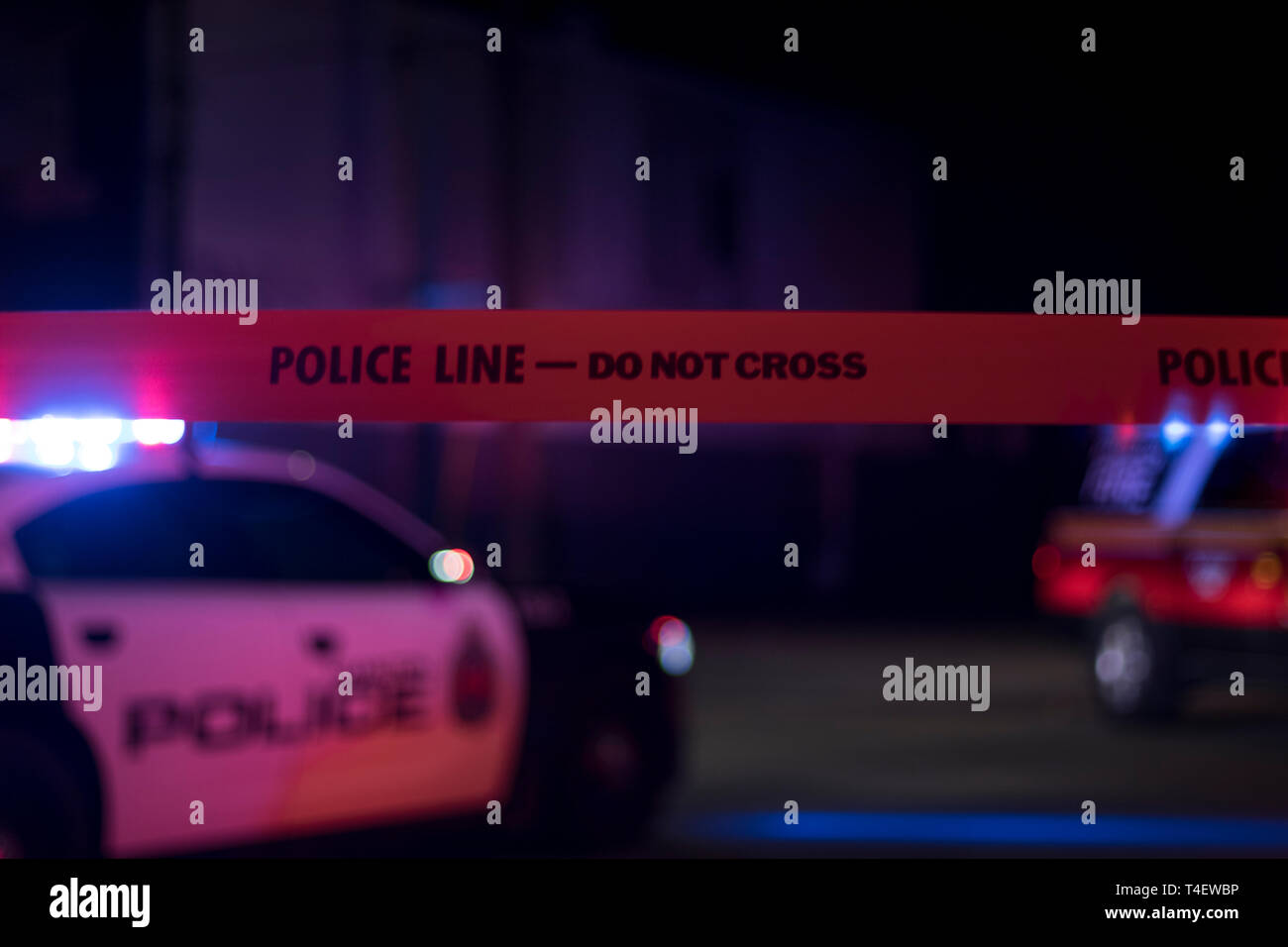 Police Line Do Not Cross yellow tape with police car with flashing lights  in the background. Crime Scene at night. 911 Emergency Stock Photo - Alamy
