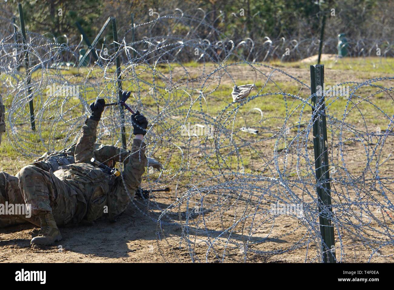 A Sapper cuts through a concertina wire obstacle before emplacing an ...