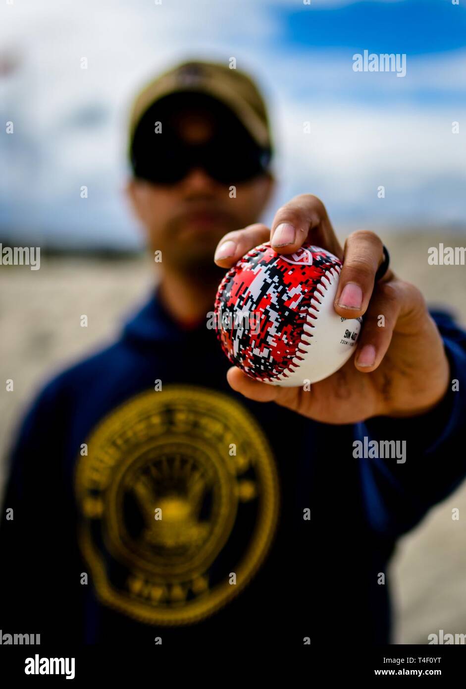 DIEGO (April 5, 2019) Aviation Electronics Technician 2nd Class Lloyd Stipe, assigned to the amphibious assault ship USS Makin Island (LHD 8), holds up a baseball found during a beach cleanup at Silver Strand State Beach. Nearly 100 Sailors volunteered to pick up trash along a 1.25-mile portion of the beach. Makin Island, homeported in San Diego, is conducting a depot level maintenance availability. Stock Photo