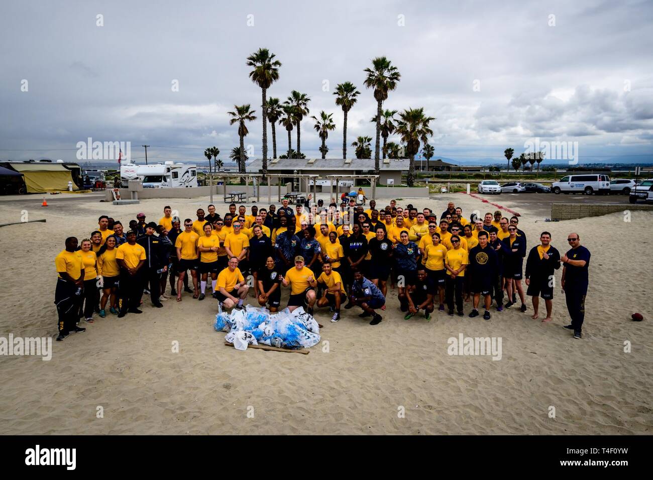 DIEGO (April 5, 2019) Sailors assigned to the amphibious assault ship USS Makin Island (LHD 8) pose for a group photo following a beach cleanup at Silver Strand State Beach. Nearly 100 Sailors volunteered to pick up trash along a 1.25-mile portion of the beach. Makin Island, homeported in San Diego, is conducting a depot level maintenance availability. Stock Photo