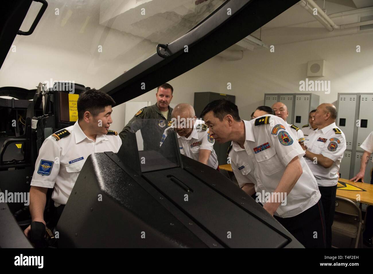 Airmen from the Mongolian Air Force Command sit in an F-22 simulator during a visit to the 154th Wing, Hawaii Air National Guard, Joint Base Pearl Harbor-Hickam, Hawaii, March 26, 2019. A delegation from the MAFC visited Pacific Air Forces as part of Airman-to-Airman talks. The multi-day event marked the first A2A talks between the United States and MAFC, a newly separated branch of the Mongolian Armed Forces. Stock Photo