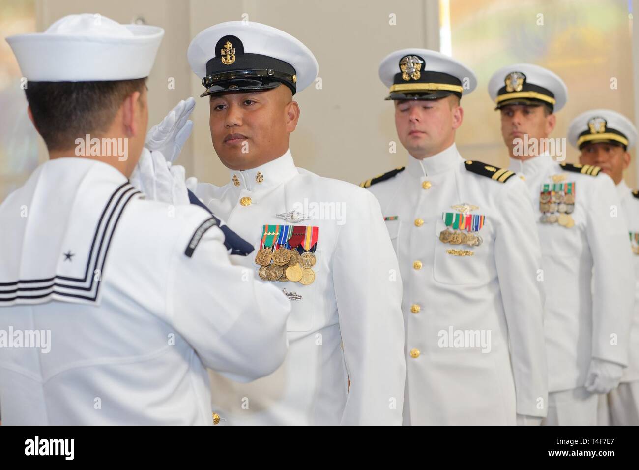 The Flag Detail passes the national ensign during the reading of 'Olde Glory' during Lt. Cmdr. Felix Villanueva’s retirement ceremony at the Chapel aboard Navy Station San Diego. Lt. Cmdr. Villanueva assigned to Navy Medicine West concluded a 28 year career on 11 April 2019 in a small ceremony surround by his family, friends, and closest colleagues. Stock Photo
