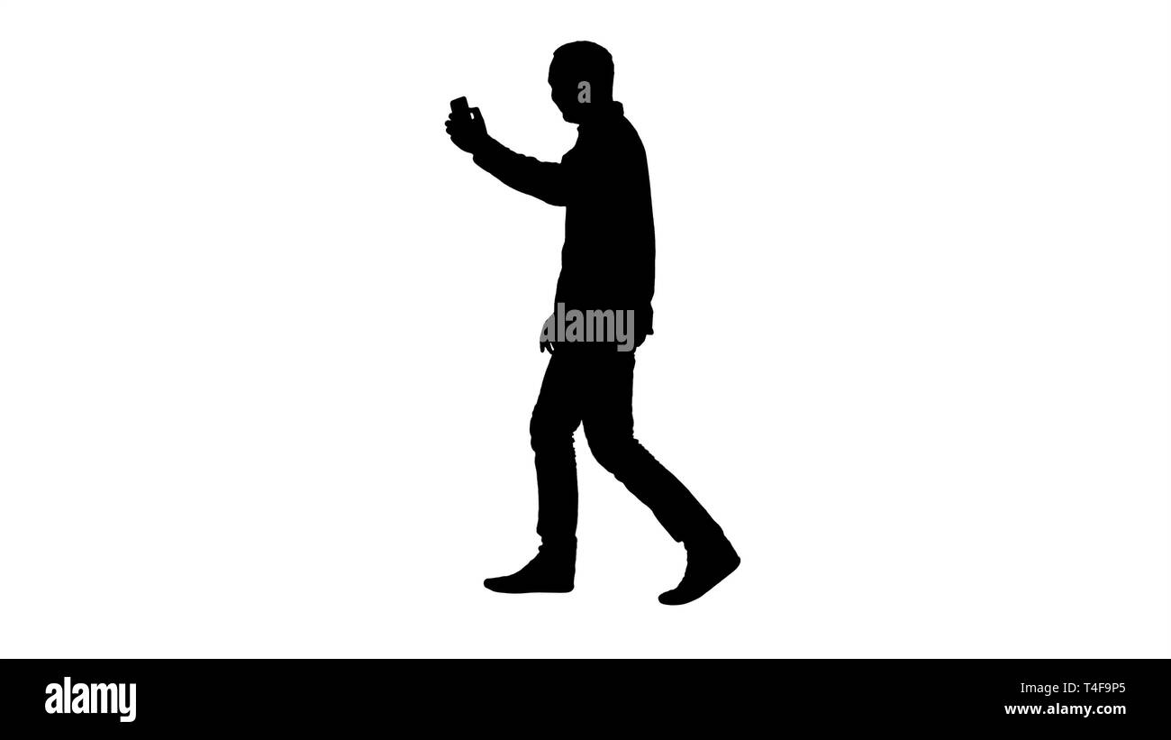 Silhouette Attractive man with short dark hair checking pictures after making selfie. Stock Photo