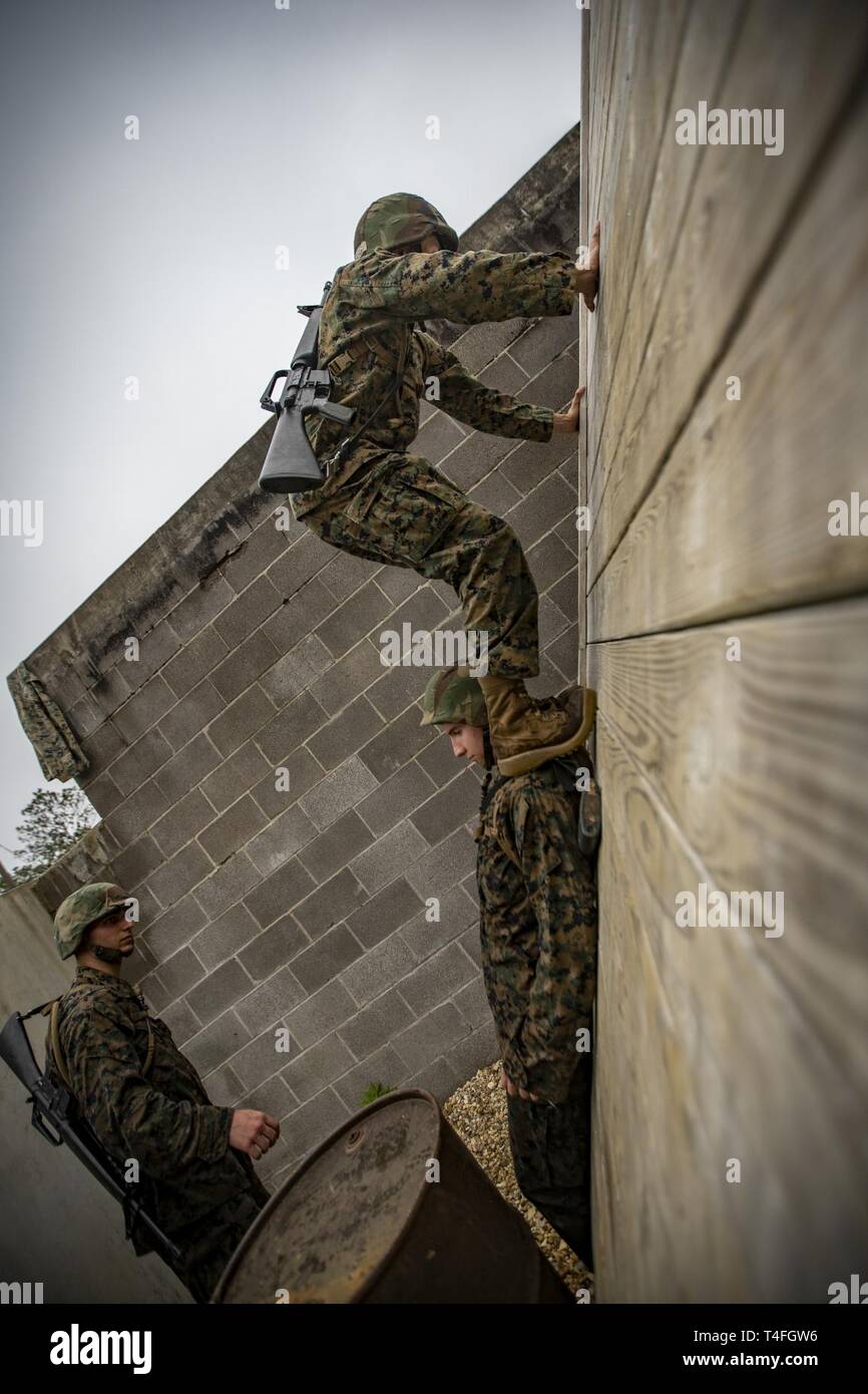 A Naval Reserve Officers Training Corps Midshipmen from Tulane University and Southern University and A&M College, climbs a wall during a leadership reaction course at Camp Shelby in Hattiesburg, Miss., April 6, 2019. Marines with Marine Forces Reserve assisted in the LRCs to provide experience and insight for midshipmen to better prepare them for Officer Candidate School and for their future military careers. Stock Photo