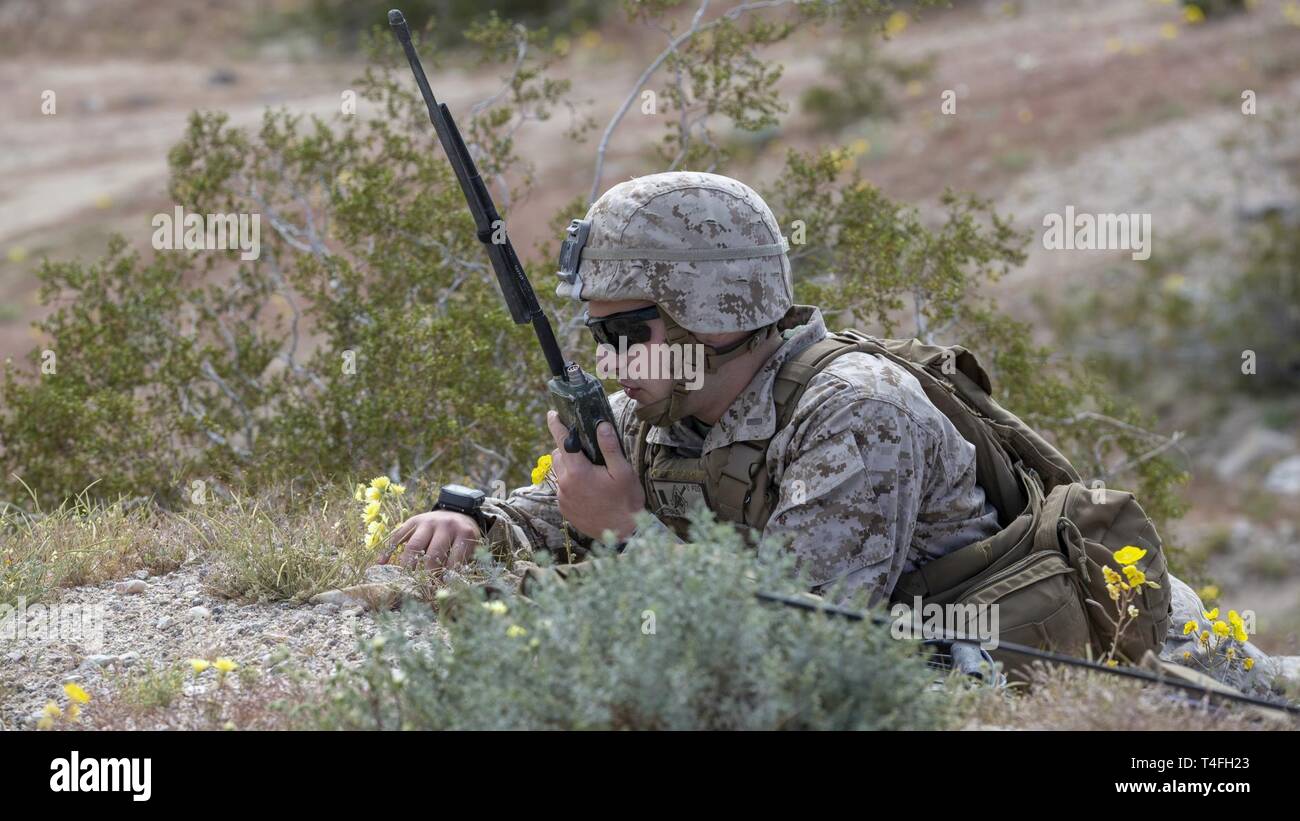 U.S. Marine Corps 2nd Lt. Adam Strausgoldfarb with 2nd Battalion, 7th Marine Regiment, 1st Marine Division (1st MARDIV), speaks through a radio during a combined arms breach at Marine Corps Air Ground Combat Center, Twentynine Palms, California, April 4, 2019.The combined arms breach increased the breaching capabilities, combat effectiveness, 1st MARDIV integration, command and control and decision-making ability of 1st Combat Engineer Battalion. Stock Photo