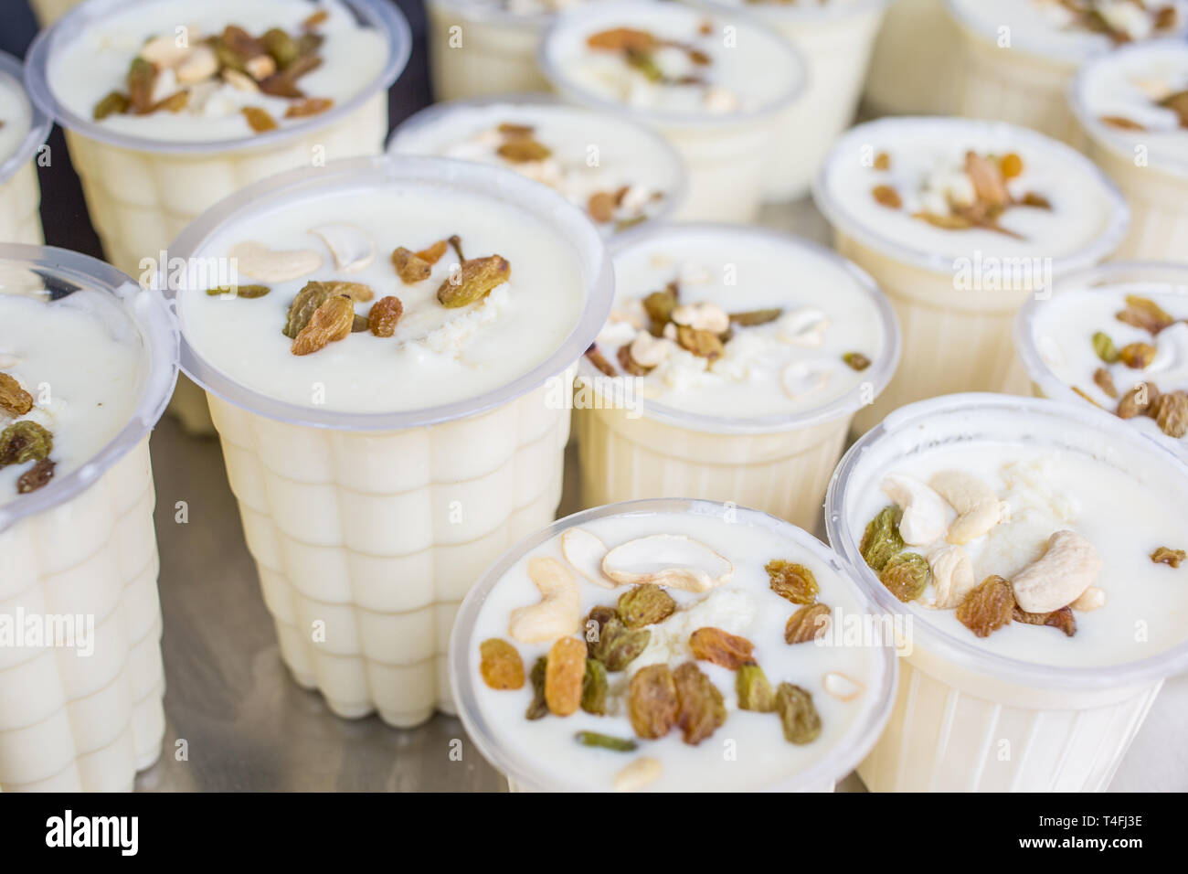 Fresh Lassi, a traditional Indian yogurt drink, in cups at a market vendor. Stock Photo