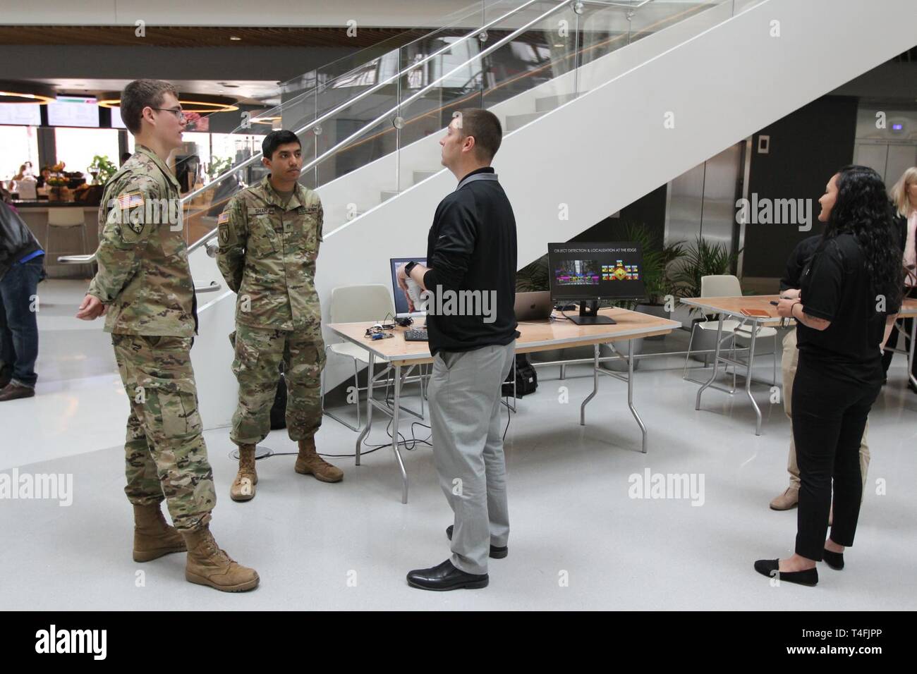BOSTON – Cadets Ian Miller (left) and Rishi Shah, from the Reserve Officer Training Corps (ROTC) program at the Massachusetts Institute of Technology, Cambridge, talk with Northeastern University students and the public about cyber and Army opportunities at Cyber Day in the ISEC Building on the Northeastern campus April 11.  Northeastern University and the Army Cyber Institute at West Point hosted a Cyber Day as a way to bring subject matter experts within the civilian and military sectors to discuss cyber topics, including: using capture-the-flag to identify talent, protection of critical inf Stock Photo