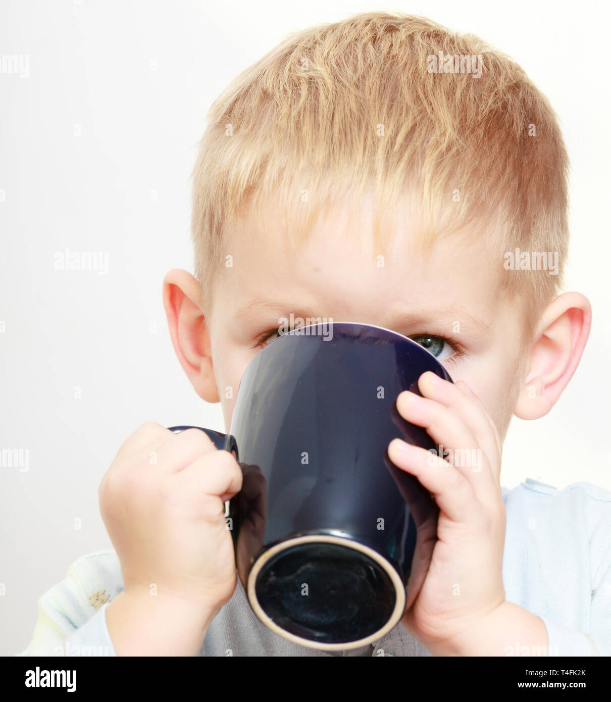 Happy childhood. Funny little boy child kid drinking tea. Indoor Stock
