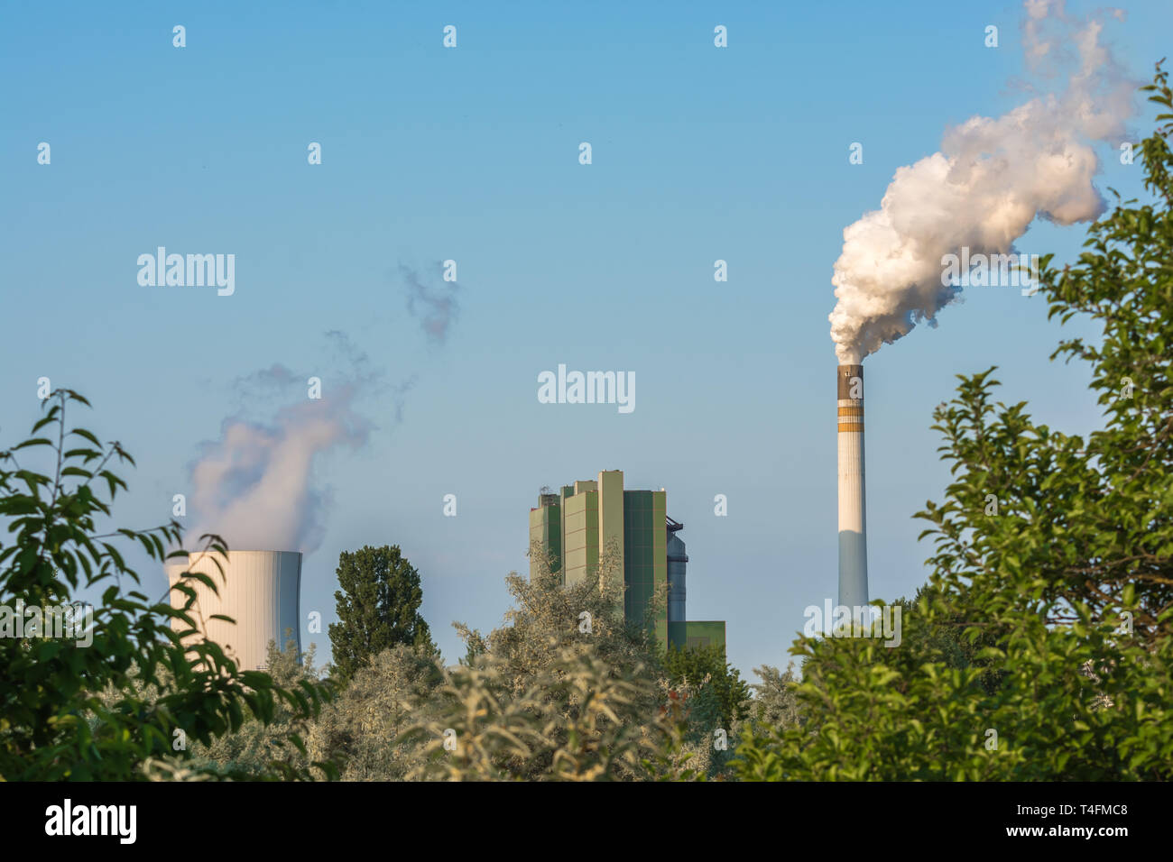 Nature under the influence of nearby power plant with heavily smoky chimney Stock Photo