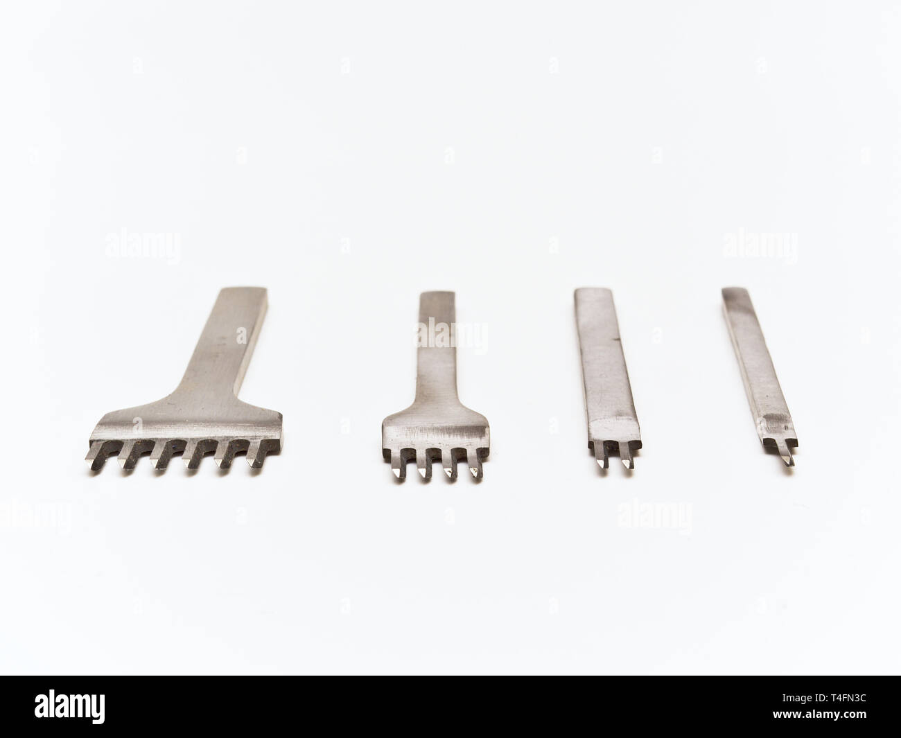 Leather working tools isolated on white background. Chisel set. One, two, four and six. Stock Photo