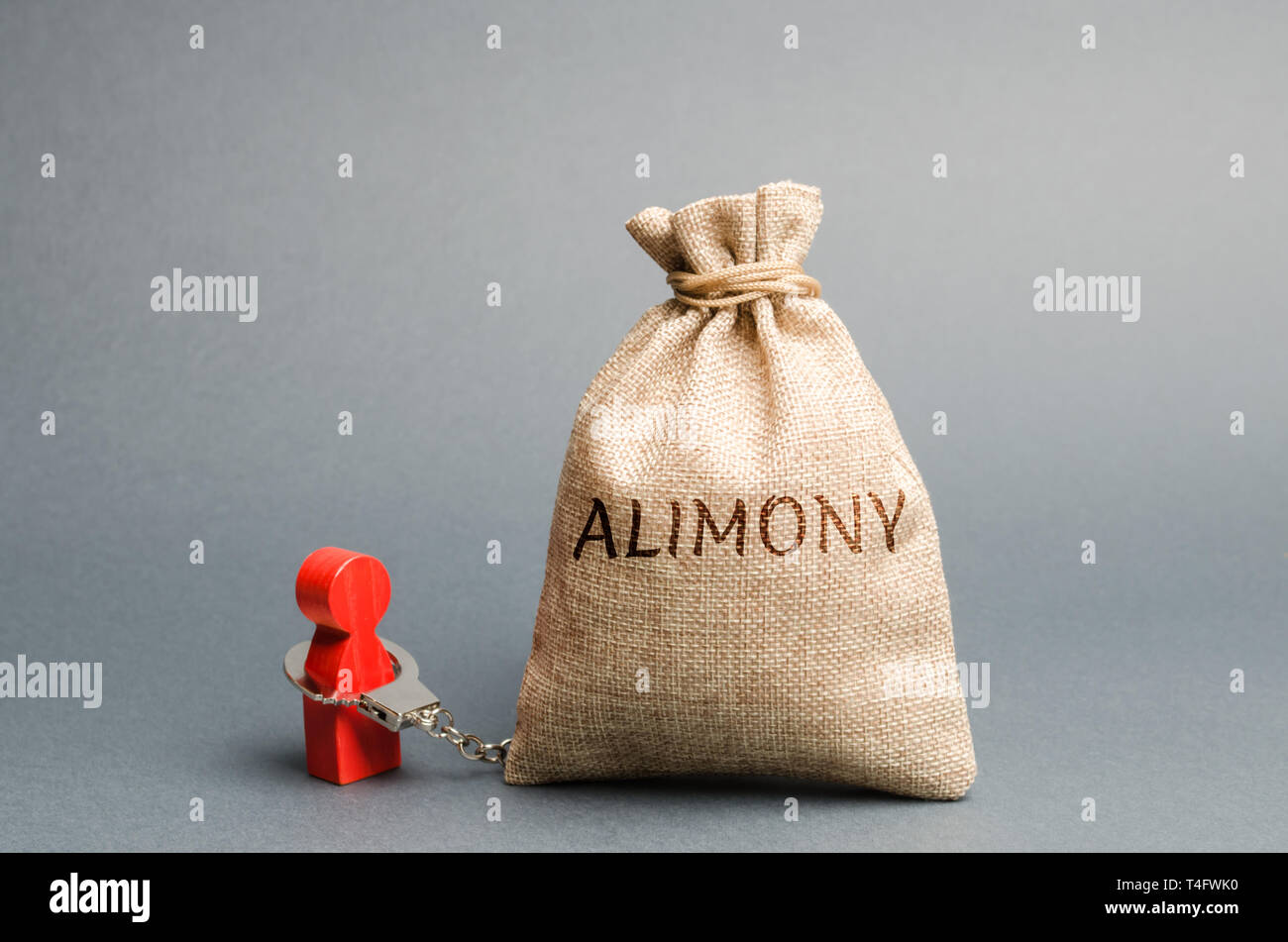 The man is handcuffed to a money bag with the word alimony. The concept of child support. Payments after a divorce. Financial support. Legal obligatio Stock Photo