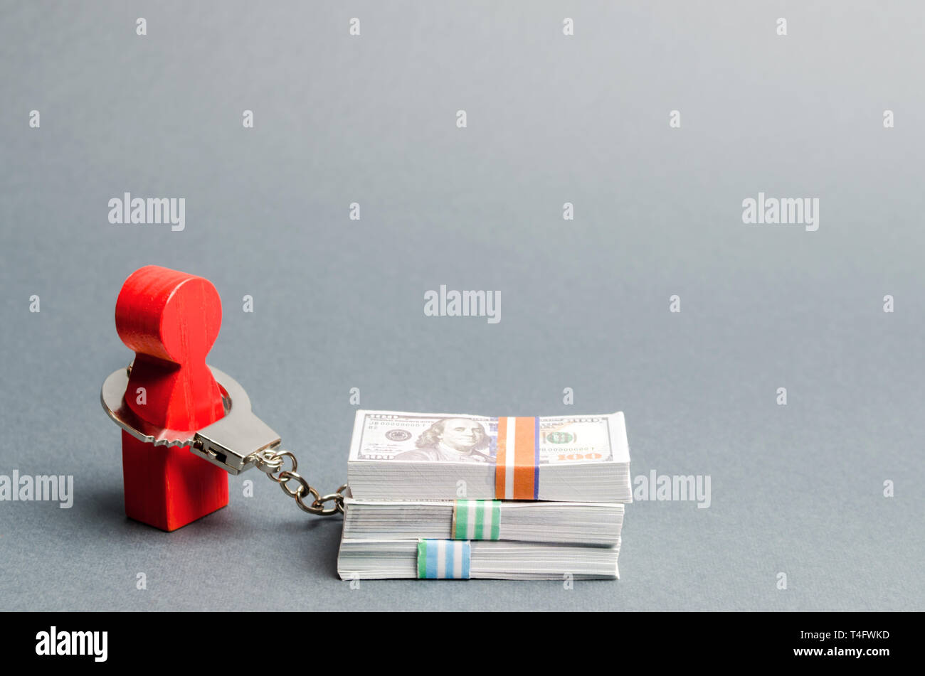 A red man is handcuffed to a money. Dependence on finance. Accumulated debts. Inability to repay loans. Unconscionable terms of the contract. Ban debt Stock Photo