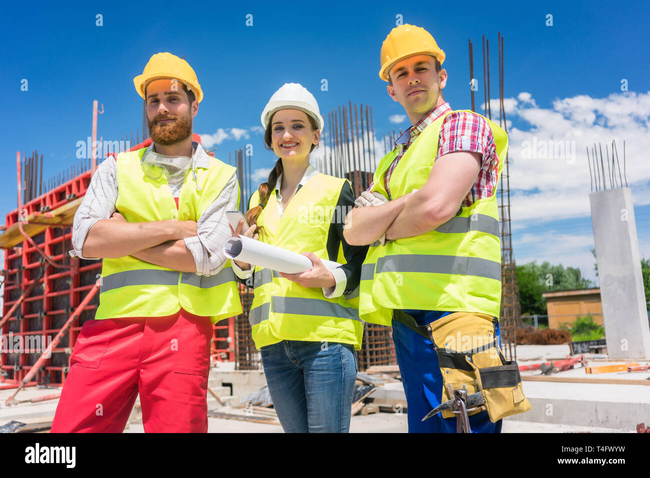 Portrait of three confident and reliable young employees at construction site Stock Photo