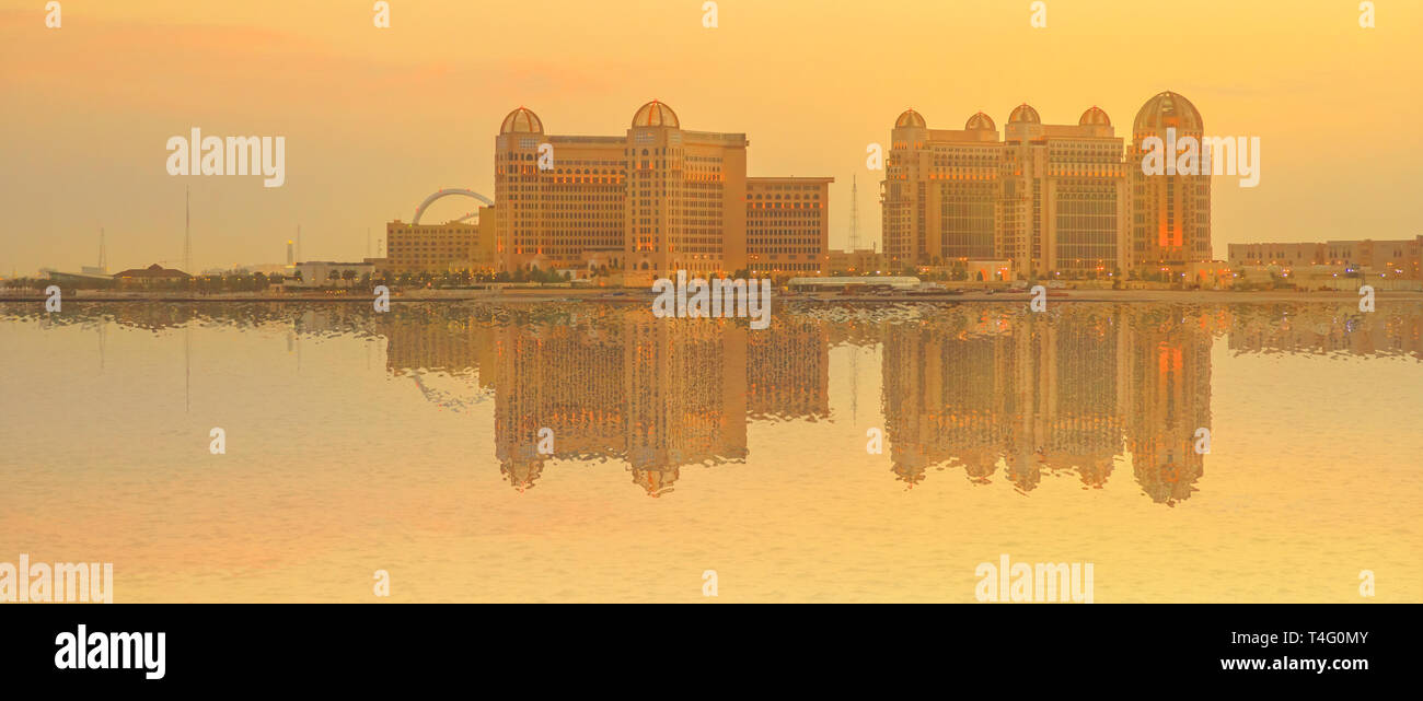 Banner cityscape of luxury resort hotel in West Bay reflecting on Doha Bay at twilight from Porto Arabia, The Pearl-Qatar's main harbor in Doha Stock Photo