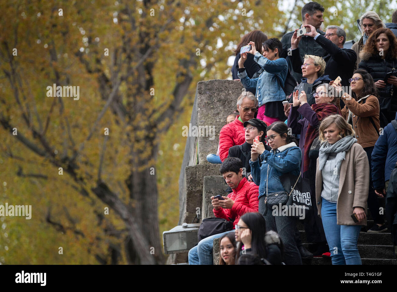 People look towards the Notre Dame Cathedral in Paris following a fire which destroyed much of the building on Monday evening. Stock Photo