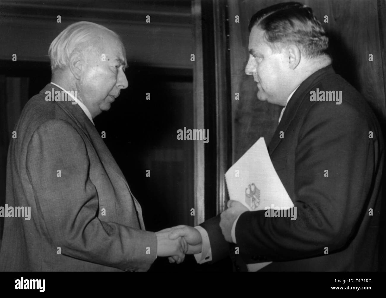 German president Theodor Heuss (r) presents the letter of appointment to Franz Josef Strauß, Germanys new secretary of defense on 18 October 1956. He succeeds Theodor Blank. | usage worldwide Stock Photo