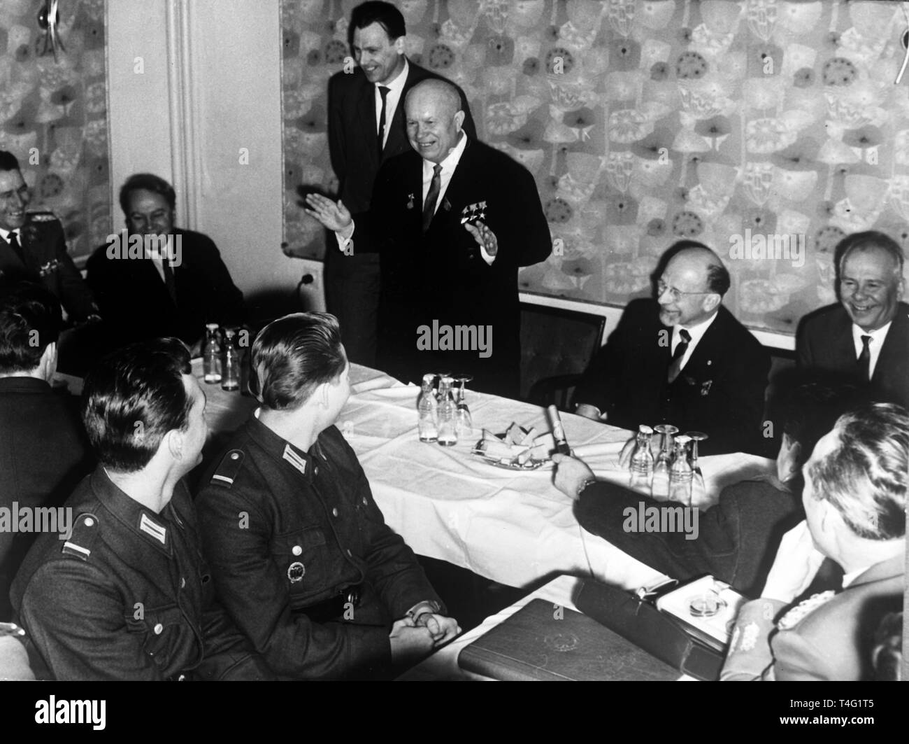 Soviet president Nikita Khrushchev (standing) talks to border soldiers of the Soviet zone army during his visit on the 17th of January in 1963. To his right head of the SED Walter Ulbricht. | usage worldwide Stock Photo