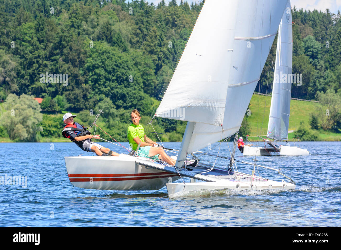 Catamaran sailing on inland lake in summertime Stock Photo