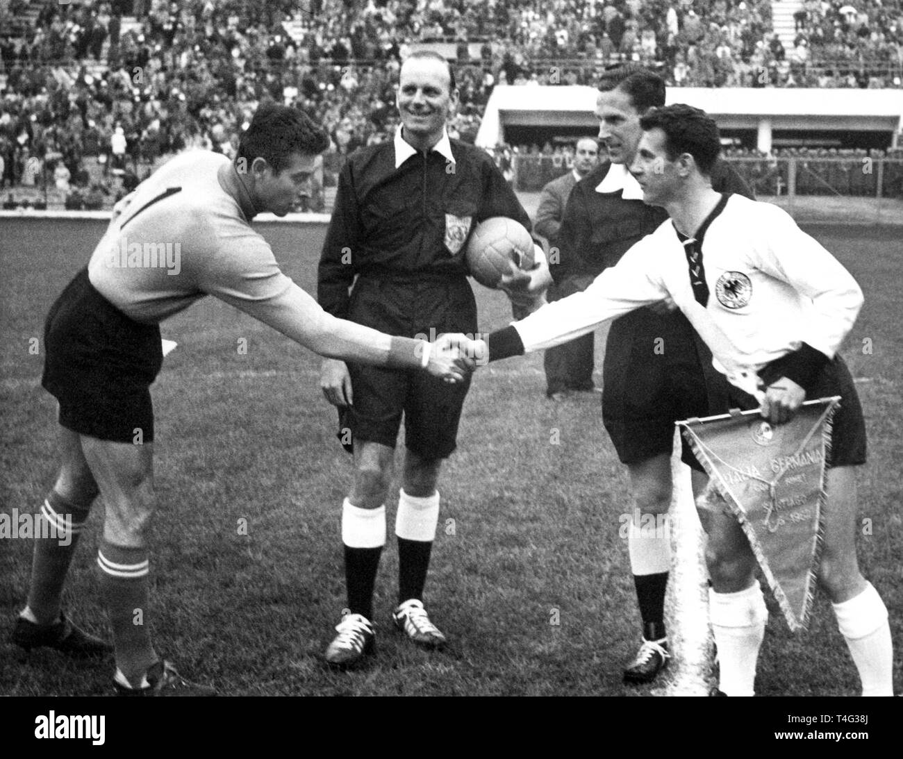 The team captains German striker Hans Schaefer (R) and Italian goalkeeper Lorenzo Buffon (L) are shaking hands prior to the 1962 FIFA World Cup group round match Germany versus Italy (0:0) at the Santiago de Chile's National stadium on May 31st. Scottish referee Bob Davidson in the center with the ball. | usage worldwide Stock Photo