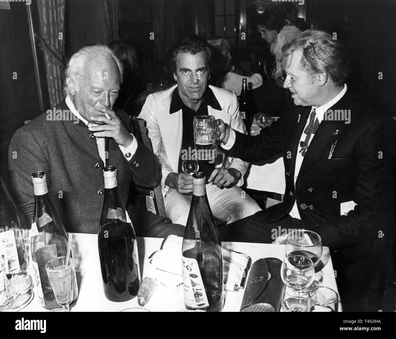 Host Curd Jürgens (l), Maximilian Schell (c), who is about to act as Jedermann during the next Festival, and Walter Reyer, Jürgens' predecessor as Jedermann, during the final party after the 'Jedermann' performance during the Salzburg Festival at castle Klessheim on 28 August 1977. | usage worldwide Stock Photo